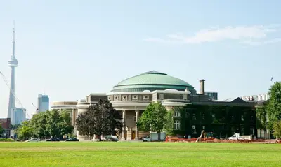 a large building with a green dome in a field at University of Toronto - New College Residence - Wilson Hall Residence in Toronto