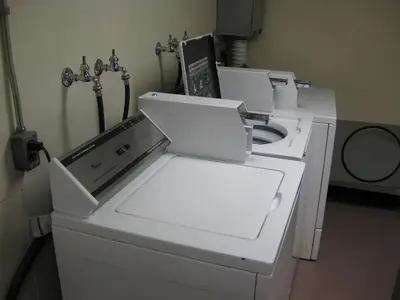 a white washing machine sitting in a room at University of Toronto - New College Residence - Wilson Hall Residence in Toronto