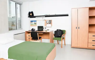 a bedroom with a bed and a desk with a computer at University of Toronto-New College Residence-45 Willcocks Residence in Toronto