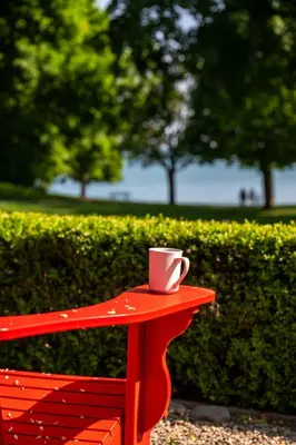 a red bench with a coffee cup on top of it at The Old Bank House in Niagara on the Lake