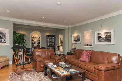 a living room with leather couches and a table at The Old Bank House in Niagara on the Lake