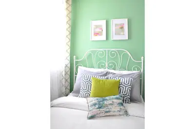 a bedroom with a white bed with a green headboard at Dream Catcher Travel House in Toronto
