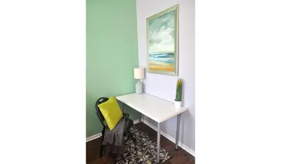 a desk in a corner of a room with a yellow chair at Dream Catcher Travel House in Toronto