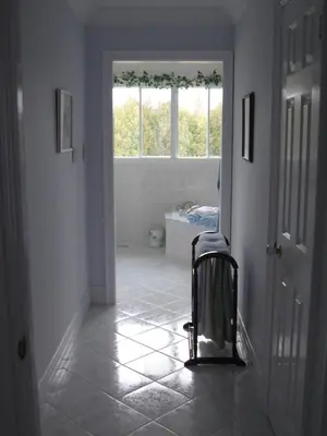 a hallway with a bathroom with a chair and a window at Molly's Retreat B and B in Orangeville