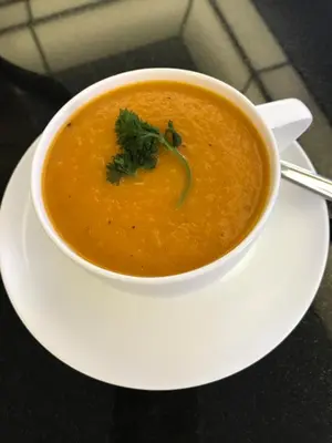 a bowl of soup on a plate on a table at Molly's Retreat B and B in Orangeville