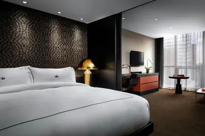a bedroom with a large white bed and a television at BISHA, a Luxury Collection Hotel, Toronto in Toronto
