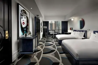 a hotel room with two beds and a sitting area at BISHA, a Luxury Collection Hotel, Toronto in Toronto