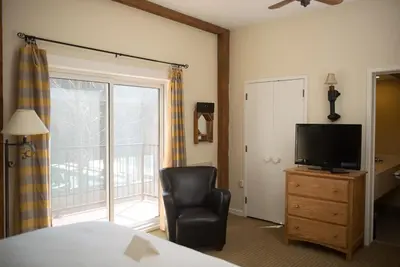 a bedroom with a bed and a chair and a television at Benmiller Inn & Spa in Goderich