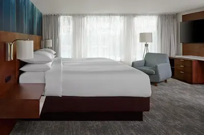 a hotel room with a large bed and a chair at Toronto Marriott City Centre Hotel in Toronto