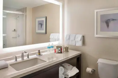 a bathroom with a sink and a toilet and a mirror at Marriott Downtown at CF Toronto Eaton Centre in Toronto