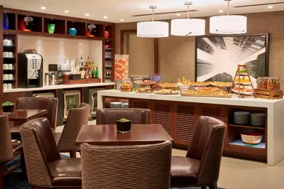 a restaurant with tables and chairs and a counter with food at Marriott Downtown at CF Toronto Eaton Centre in Toronto