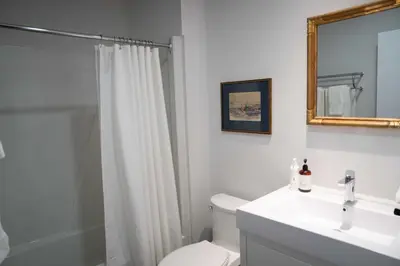 a bathroom with a sink and a toilet and a mirror at South Landing Inn in Niagara on the Lake