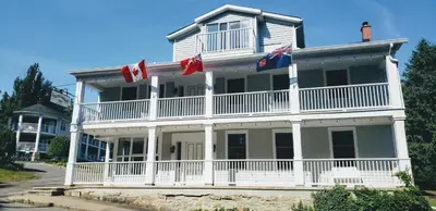 a large white house with american flags on it at South Landing Inn in Niagara on the Lake