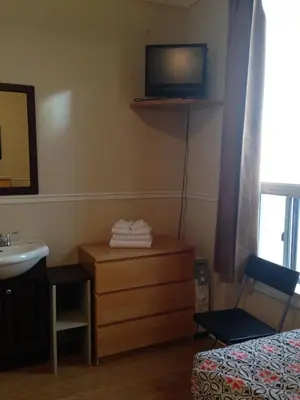 a bedroom with a bed and a sink and a television at The Rex Hotel Jazz & Blues Bar in Toronto