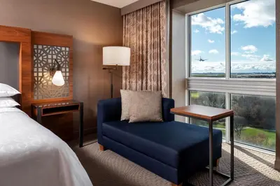 a hotel room with a bed and a chair and a window at Sheraton Toronto Airport Hotel & Conference Centre in Toronto