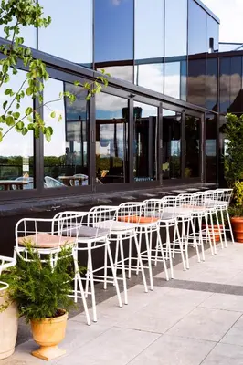 a row of white tables and chairs in front of a building at The Broadview Hotel in Toronto