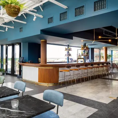 a bar in a restaurant with blue walls and chairs at The Broadview Hotel in Toronto