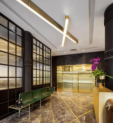 a lobby with a green bench and a elevator at The Broadview Hotel in Toronto