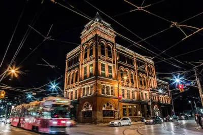 a large building with a clock tower at night at The Broadview Hotel in Toronto