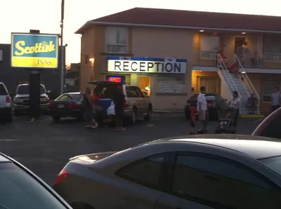 a parking lot with cars parked in front of a restaurant at Scottish Inn Near the Falls and Casino in Niagara Falls