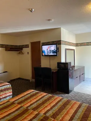 a hotel room with a bed and a flat screen tv at Scottish Inn Near the Falls and Casino in Niagara Falls
