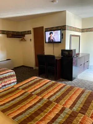 a hotel room with a bed and a flat screen tv at Scottish Inn Near the Falls and Casino in Niagara Falls