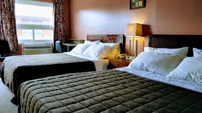 a hotel room with two beds and a window at Kings Inn Midland in Midland