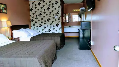 a hotel room with two beds and a refrigerator at Kings Inn Midland in Midland