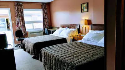 a hotel room with two beds and a window at Kings Inn Midland in Midland
