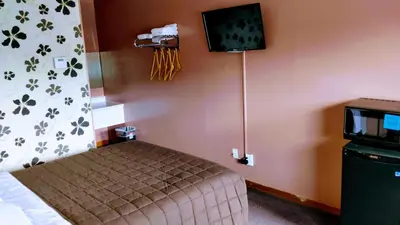 a bedroom with a bed and a tv on the wall at Kings Inn Midland in Midland
