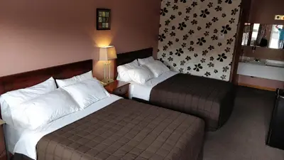 a hotel room with two beds and a window at Kings Inn Midland in Midland