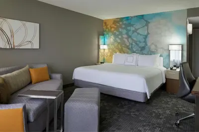 a hotel room with a bed and a couch at Courtyard by Marriott Toronto Airport in Toronto