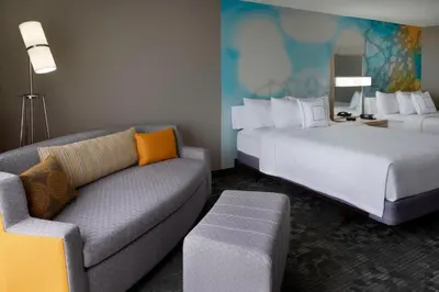 a hotel room with a bed and a couch at Courtyard by Marriott Toronto Airport in Toronto