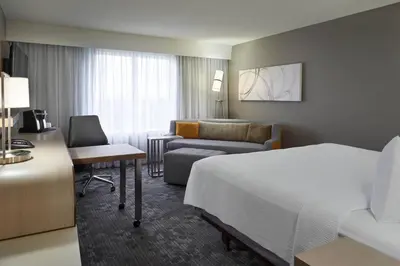 a hotel room with a bed and a couch at Courtyard by Marriott Toronto Airport in Toronto