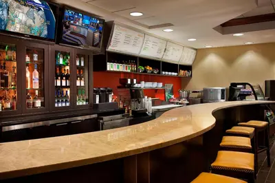 a bar in a restaurant with a counter and stools at Courtyard by Marriott Toronto Airport in Toronto