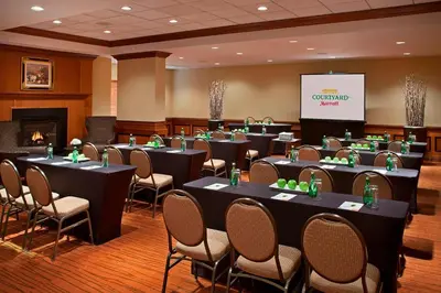 a conference room with tables and chairs and a screen at Courtyard by Marriott Toronto Airport in Toronto