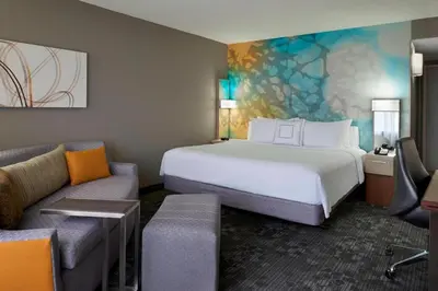 a hotel room with a large bed and a couch at Courtyard by Marriott Toronto Airport in Toronto