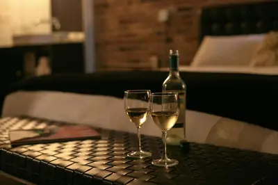 two glasses of white wine on a table with a bottle at Hotel Metro in London