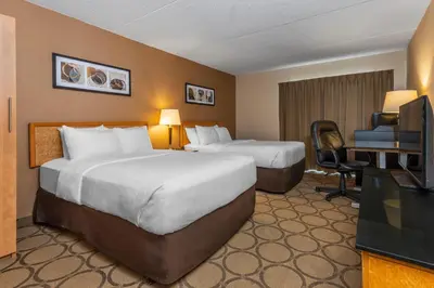 a hotel room with two beds and a desk and a television at Comfort Inn in Simcoe