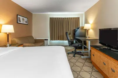 a hotel room with a bed and a desk and a television at Comfort Inn in Simcoe