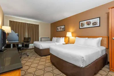 a hotel room with two beds and a television at Comfort Inn in Simcoe