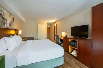 a hotel room with a bed and a flat screen tv at Comfort Inn in Newmarket