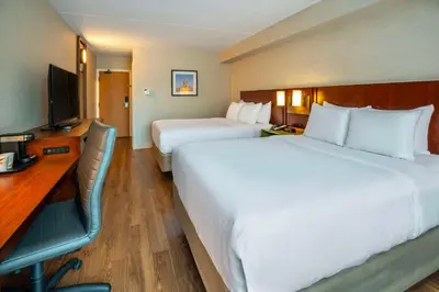 a hotel room with two beds and a desk and a television at Comfort Inn in Newmarket