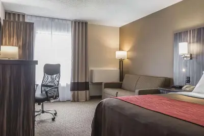 a hotel room with a bed and a chair at Comfort Inn Trenton in Trenton