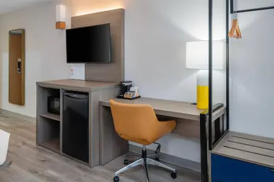 a room with a desk with a television and a chair at Comfort Inn in Belleville