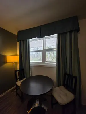 a table and chairs in a room with a window at Shenstone Motor Inn in Wiarton