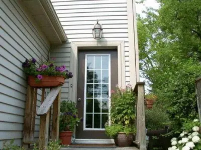 a house with a door with potted plants on it at Antique Slumber Old Town Bed & Breakfast in Niagara on the Lake