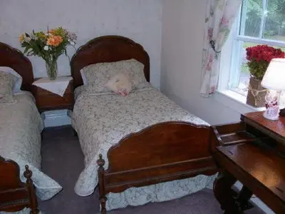 a bedroom with two beds with a stuffed animal sleeping on it at Antique Slumber Old Town Bed & Breakfast in Niagara on the Lake
