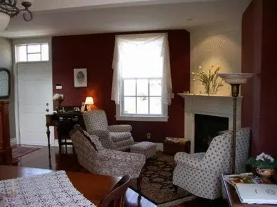 a living room with chairs and a fireplace at Antique Slumber Old Town Bed & Breakfast in Niagara on the Lake