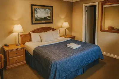 a hotel room with a bed and two lamps at Empress Inn and Suites by the Falls in Niagara Falls
